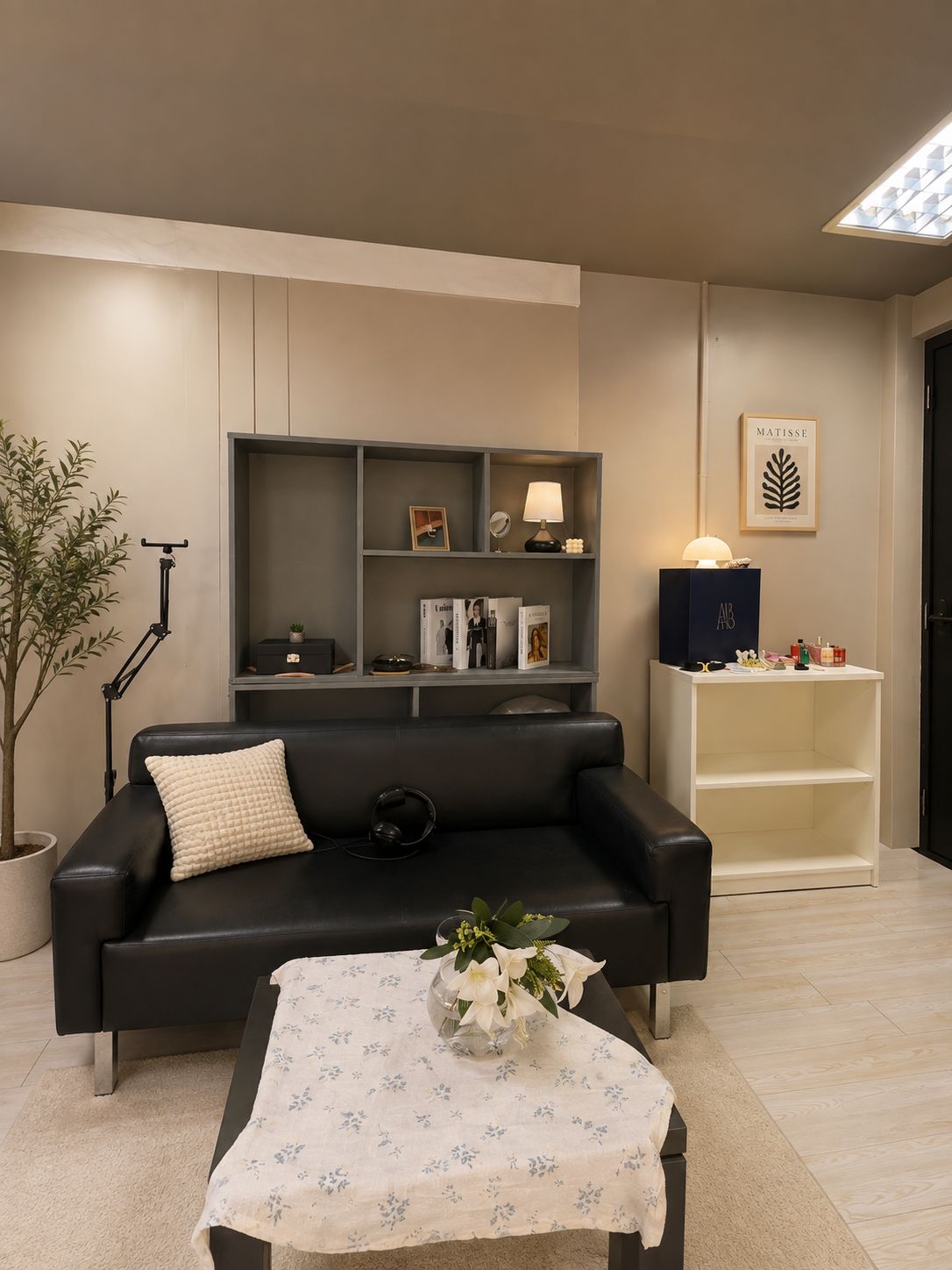 COCUT Studio interior - black leather sofa and bookshelf set